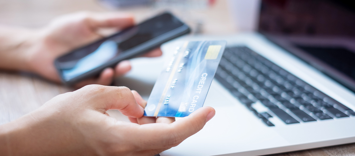 woman hand holding credit card with using smartphone and laptop for online shopping while making orders at home. business, lifestyle, technology, ecommerce, digital banking and online payment concept