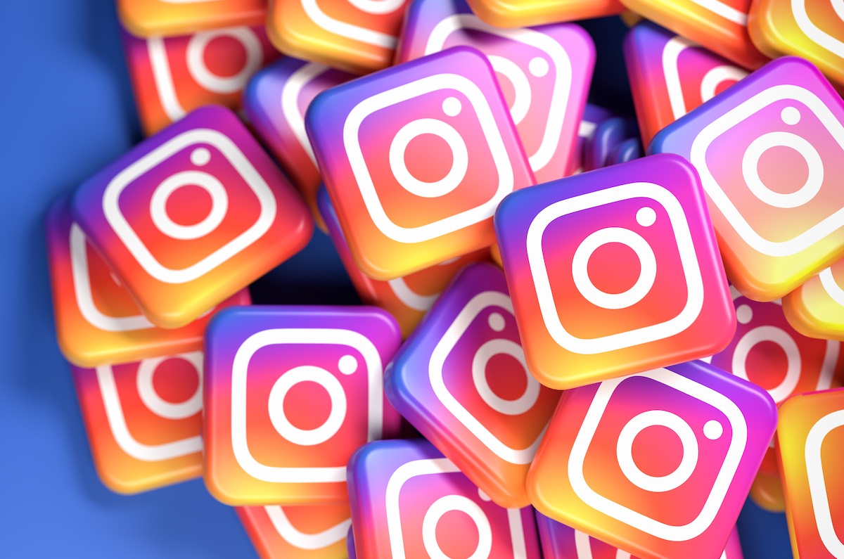 Logos of the social media image and video sharing site and app Instagram (part of Facebook) on a heap. Web banner size with copy space – Selective focus