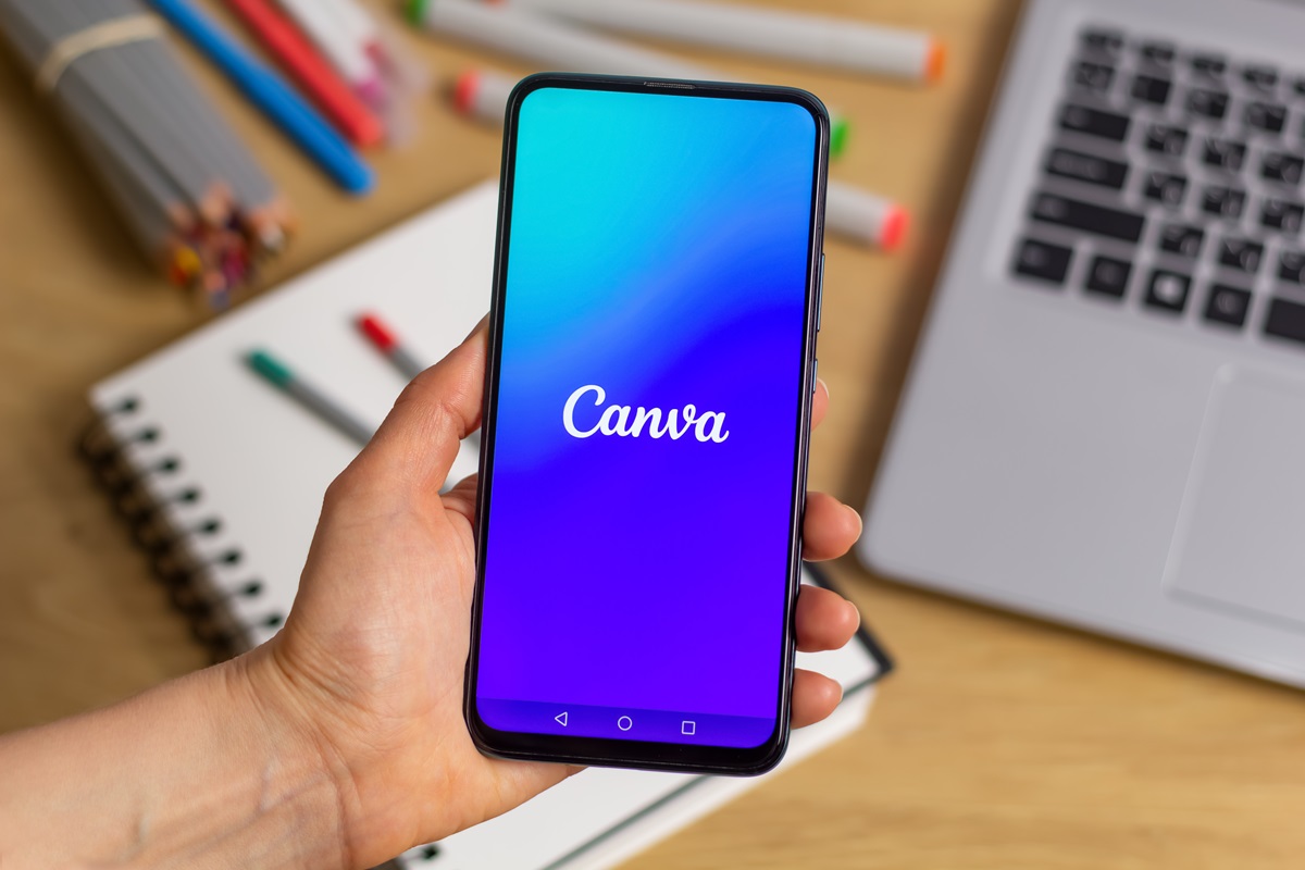 Canva logo on the screen of a mobile phone in hand.