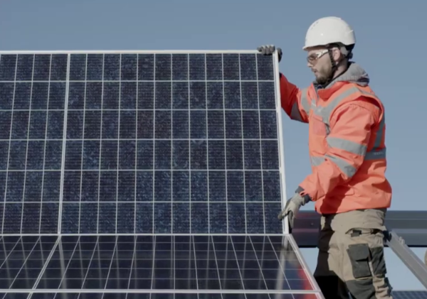 Ouvrier en tenue de sécurité tient un panneau photovoltaïque