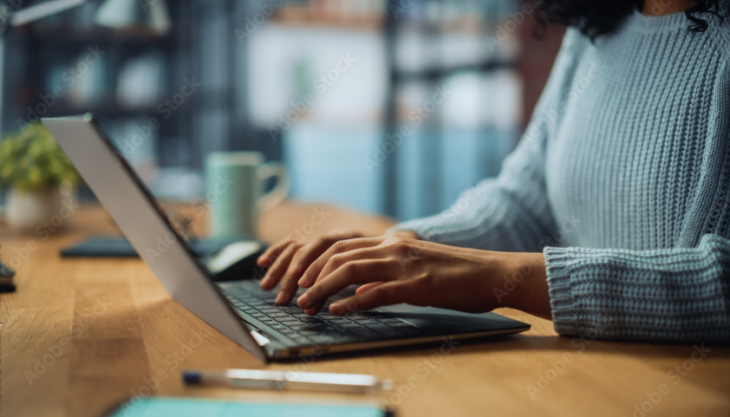 Mains d'une femme sur un clavier d'ordinateur