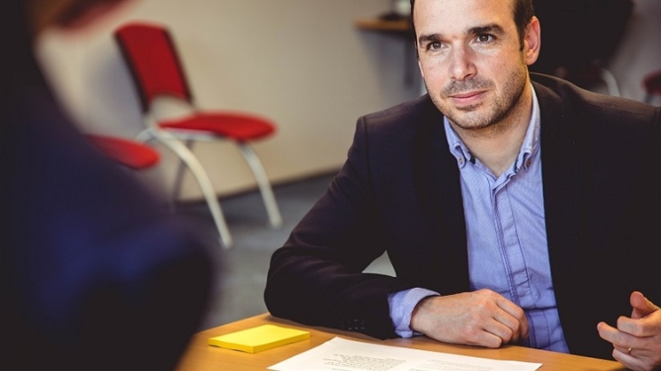 Un homme est en entretien professionnel devant une personne de dos