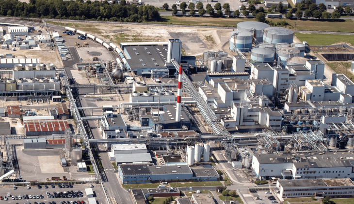 Vue aérienne du site de prodution de l'entreprise Eurolysine avec de nombreux bâtiments, des routes et du trafic de marchandises.
